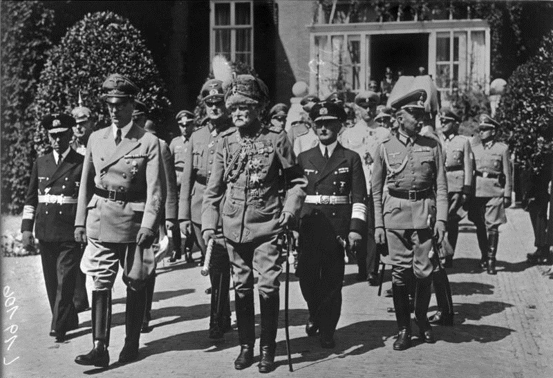 Scherl: Die Beisetzung des ehemaligen Kaisers Wilhelm II.Unter Teilnahme einer großen Trauergemeinde und der Bevölkerung von Doorn wurde Wilhelm II. im Park des Schlosses Doorn mit militärischen Ehren beigesetzt.UBz: Reichsminister Dr. Seyß-Inquart, neben ihm Generalfeldmarschall v. Mackensen. In der 2. Reihe v.l. Admiral Canaris für den Chef des Oberkommandos der Wehrmacht, General der Flieger Christiansen für den Reichsmarschall (fast völlig verdeckt), Generaloberst Haase für den Oberbefehlshaber des Heeres und Admiral Densch als Vertreter für den Oberbefehlshaber der Kriegsmarine. Scherl Bilderdienst (Fritz) Juni 1941 "Fr" OKWADN-ZB: Die Niederlande während der faschistischen deutschen Besetzung, Juni 1941 Der ehemalige deutsche Kaiser Wilhelm II. (geb. 27.1.1859) starb am 4.6.1941 in Doorn, seinem niederländischen Exil. Während der Beisetzung im Park des Schlosses Doorn 1.R.v.l. Reichsminister Arthur Seyß-Inquart und Generalfeldmarschall August von  Mackensen, 2.R.v.l. Admiral Wilhelm Canaris, Generaloberst Kurt Haase und Admiral Herman Densch. Aufnahme: Fritz